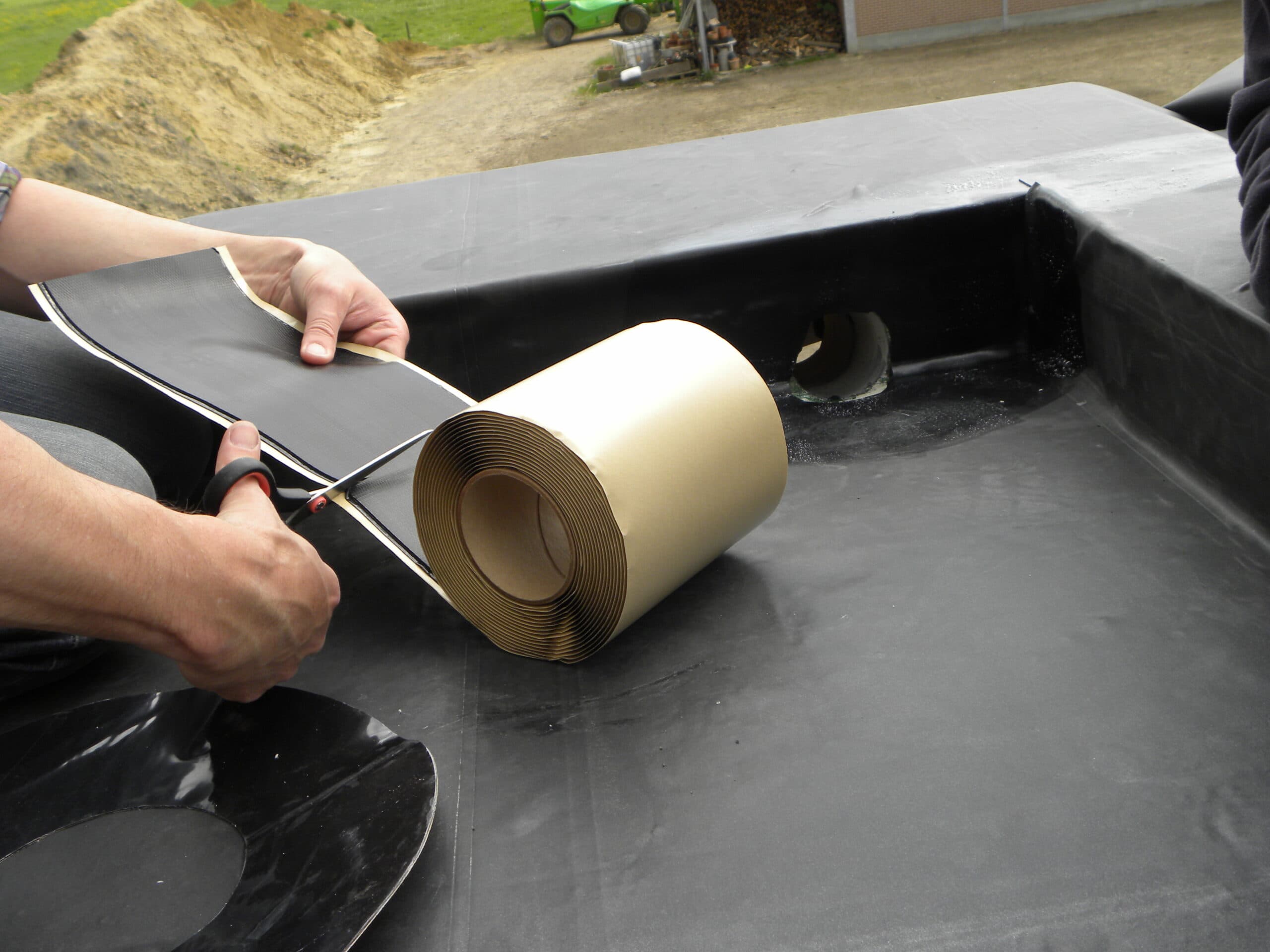 Een dakwerker brengt RoofCover EPDM tape aan op een naad